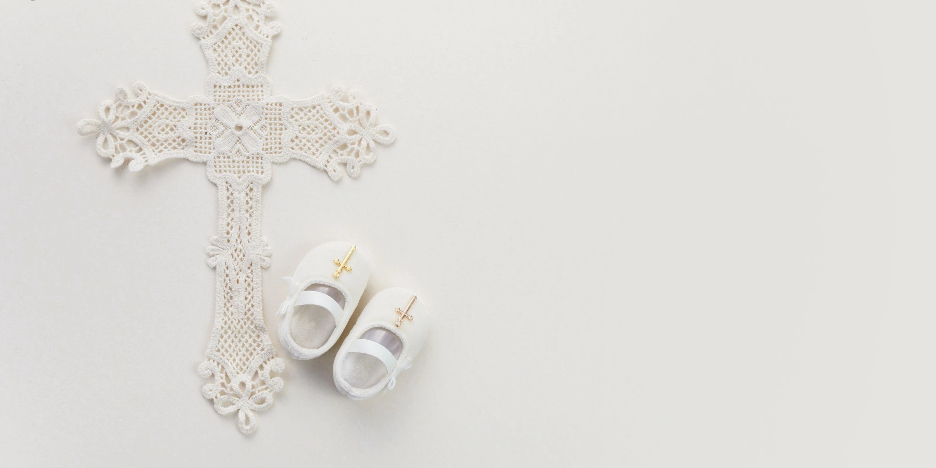 Konfirmationsfeier mit symbolischen Elementen - weißes Kreuz neben eleganten schwarzen Konfirmationsschuhen, auf hellem Untergrund mit Blütenblättern zur Feier des evangelischen Glaubensbekenntnisses