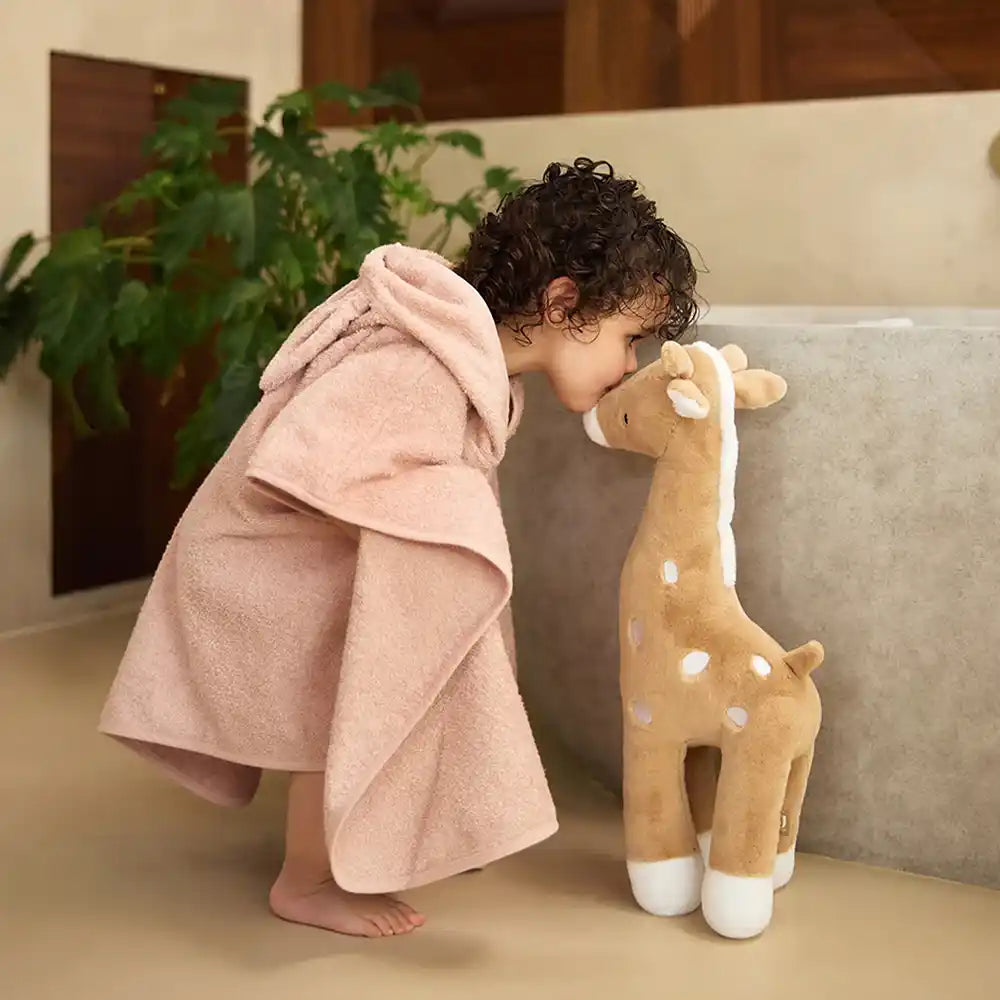 Kapuzenhandtuch Baby personalisiert in Rosé mit Kleinkind und Plüschgiraffe nach dem Baden.