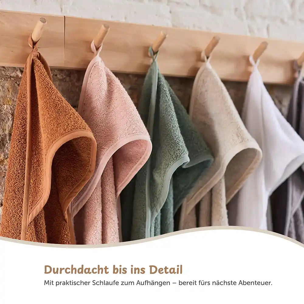 Kapuzenhandtuch Baby personalisiert in verschiedenen Farben an einer Wand zum Aufhängen.