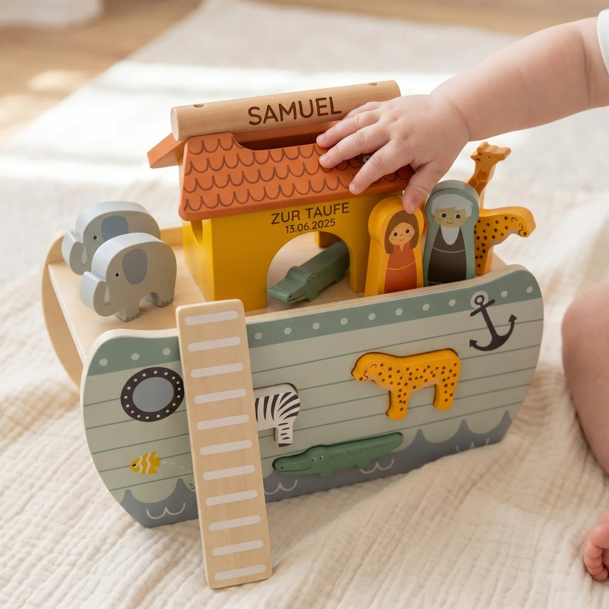 Arche Noah personalisiert zur Taufe, Babyhand sortiert die Tiere ein