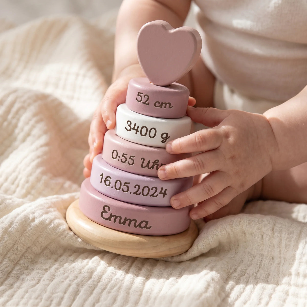 Stapelturm personalisiert in Rosa, Babyhände stapeln die Ringe