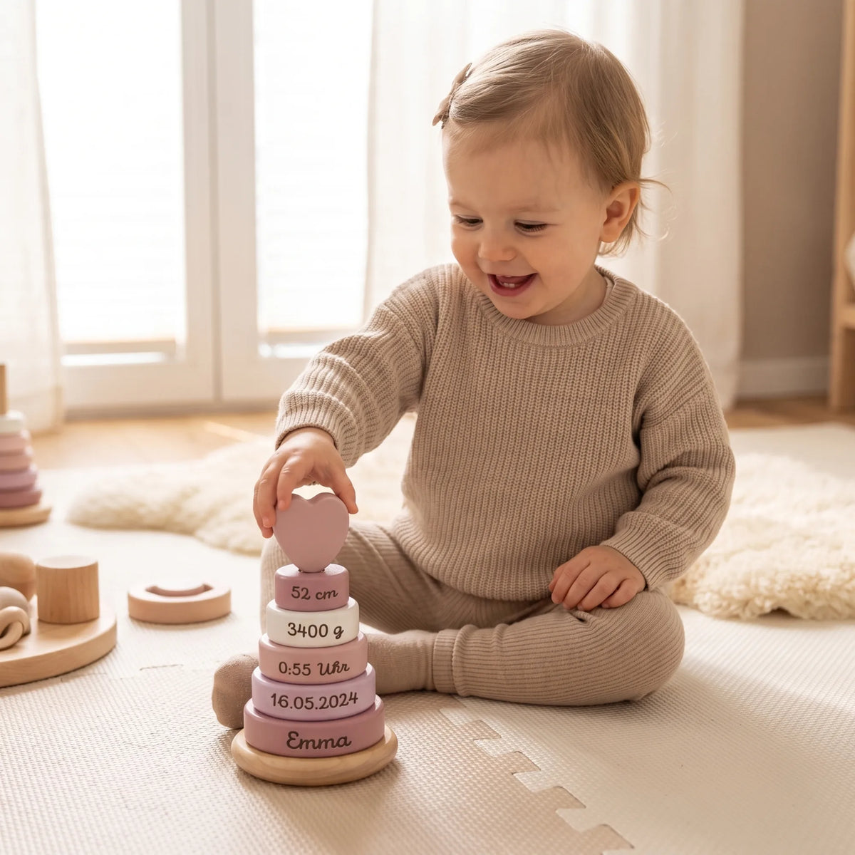 Stapelturm personalisiert in Rosa, Kind stapelt lachend