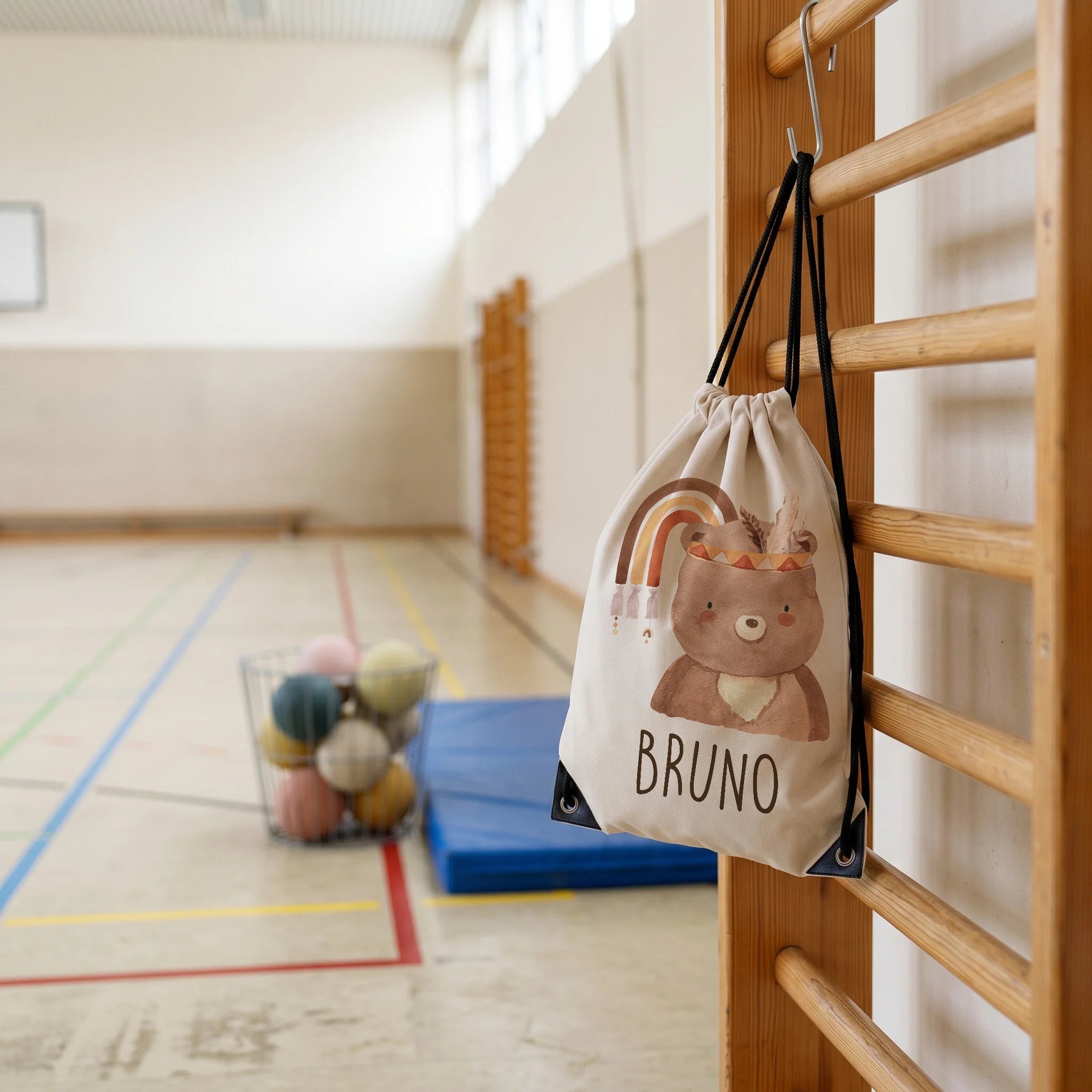 Personalisierter Turnbeutel Bär mit Regenbogen, im Sportunterricht in der Turnhalle