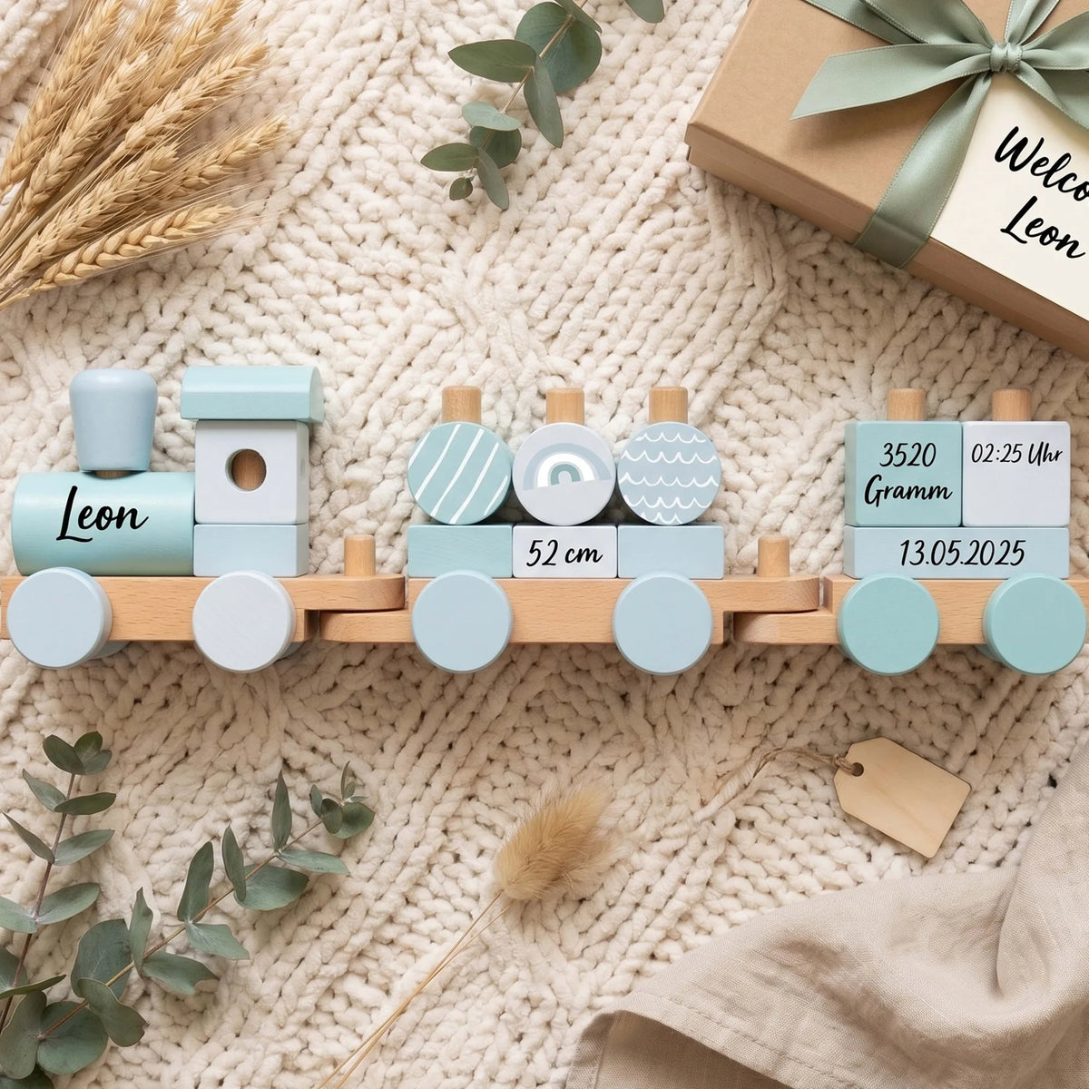 Holzzug personalisiert in Blau neben einer Geschenkverpackung (Deko)