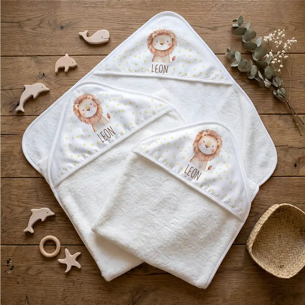 Personalisiertes Kapuzenhandtuch Baby Löwe Sterne – Flatlay mit Eukalyptus und Beißring