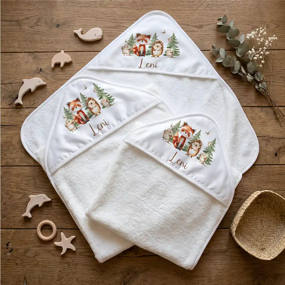 Personalisiertes Kapuzenhandtuch Baby Waldfreunde Tannen – Flatlay mit Eukalyptus und Beißring